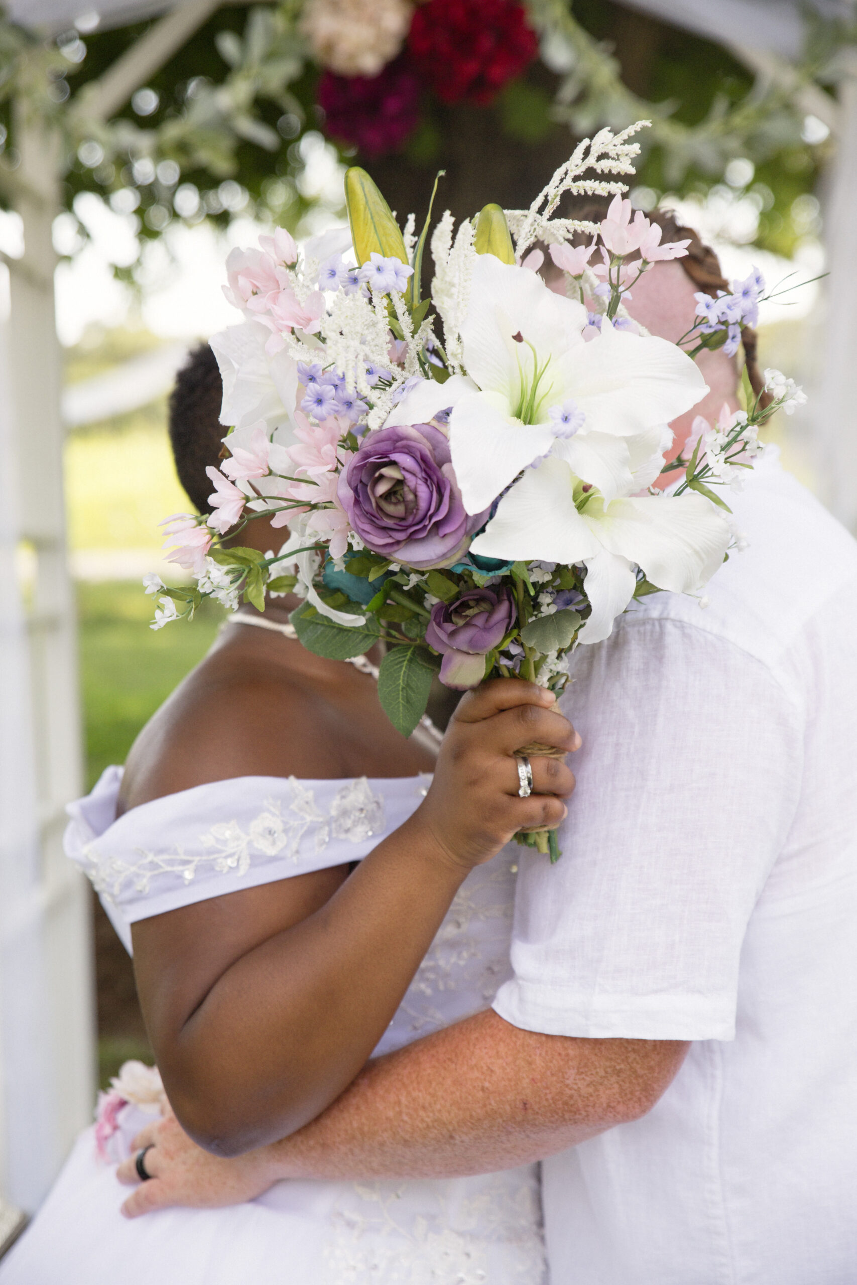 lgbtq couple kissing behind the bouquet